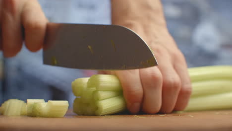 Close-up-of-cut-celery-on-a-board-in-the-kitchen-with-a-knife.